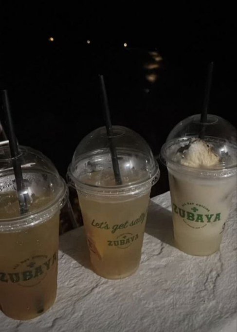 Three plastic cups from Zubaya Cold Coffee—labeled with "Let's get daily" and the Zubaya logo—sit on a stone ledge at night, containing iced beverages and straws, with distant lights in the background.

The image has no direct connection to the accompanying post about NFT whitelist spots, Robinhood chain mints, or free mint partnerships—it appears to be a casually shared nighttime beverage photo that doesn't visually reinforce or illustrate the promotional crypto/NFT announcement.