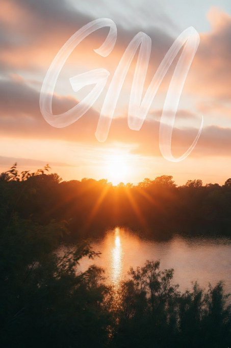 A serene sunset over a lake reflecting the golden light, with the word 'GOD' written in a smoke-like, transparent script across the sky.