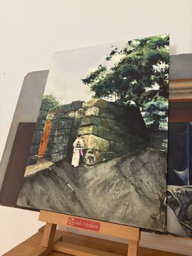 A painting on an easel depicting a person standing next to stone ruins with a large tree in the background, with a red 'natraj' sticker on the easel.