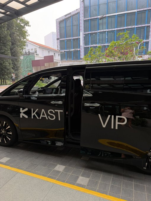 A black VIP van with sliding doors open, displaying 'KAST VIP' branding on the side, parked outside a building.