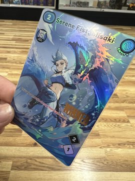 A close-up of a hand holding a trading card titled 'Serene Fist Milsiraki' featuring anime-style artwork.
