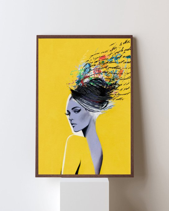 A framed art print featuring an illustrated woman with vibrant, paint-splattered hair against a bright yellow background, with cursive script overlay.