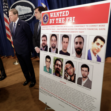 Officials stand beside an FBI "Wanted by the FBI" poster targeting members of Iran's Mabna Institute for an alleged hacking-for-hire conspiracy, which the accompanying post links to a $16.8 million movement of Bitcoin, Ethereum, and TRON cryptocurrency linked to the group since 2018.