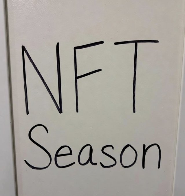 Handwritten black text on a cream-colored surface reads 'NFT Season'.