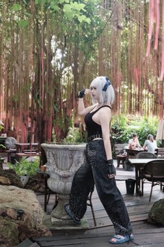 A woman with white hair and sunglasses poses on a wooden deck in a lush garden setting with hanging vines and stone planters, drinking from a cup. The image accompanies a post about attending EthShanghai 2022, an Ethereum-focused event she had been preparing for half a year before Shanghai's lockdown, hosted by Mask Network.