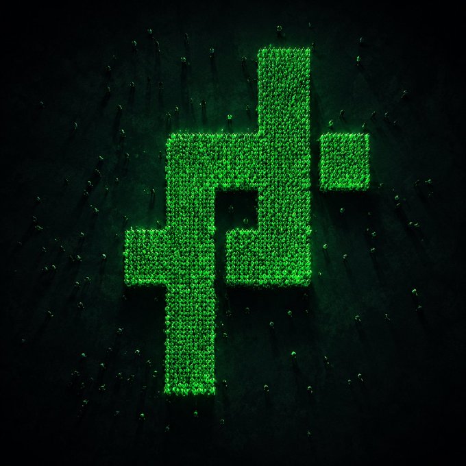 An aerial view of people arranged to form a large green and black symbol resembling a cryptocurrency logo on a dark surface.