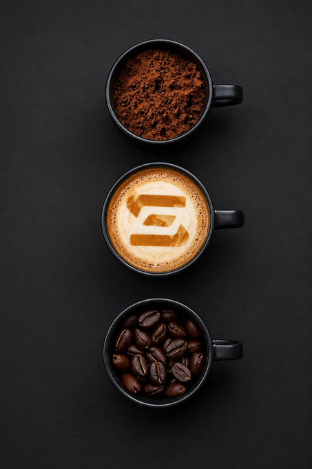 Three black coffee cups arranged vertically on a dark background showcase the journey of coffee—from whole roasted beans at the bottom, to a latte with the number "6" artfully drawn in the foam in the middle, to fresh coffee grounds at the top. The image ties into the bullish "Gm" post by symbolically depicting coffee's evolution as fuel for a strong, upward-trending day.