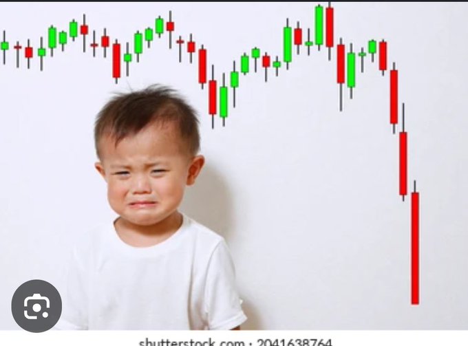 A stock photo of a crying young boy in a white t-shirt standing in front of a candlestick chart with a sharp red downward trend, symbolizing market losses.