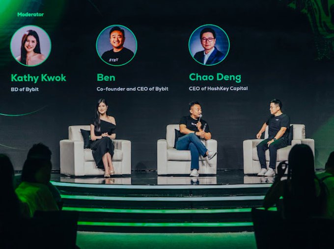 A stage panel features three people seated in white chairs under a large screen displaying "Moderator Kathy Kwok", "Ben Co-founder and CEO of Bybit", and "Chao Deng CEO of HashKey Capital".
