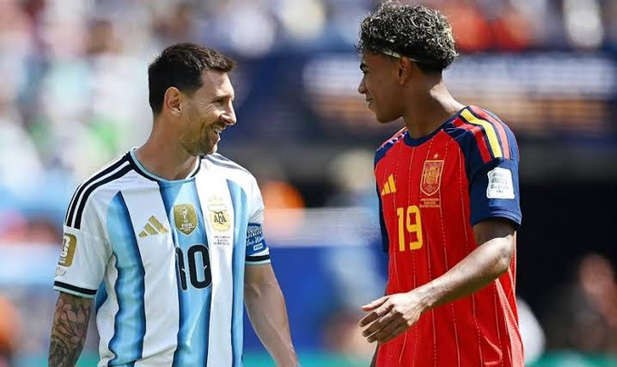 Lionel Messi (#10) in Argentina's light blue and white striped jersey shares a smiling exchange with a young Spain player (#19) in a red jersey on the pitch, capturing the friendly rivalry between the two nations likely during the 2026 FIFA World Cup final. The image ties directly to the post's observation about timelines shifting from crypto and AI talk to football discussions, visually representing the Argentina vs. Spain matchup that has fans debating and celebrating across social media.