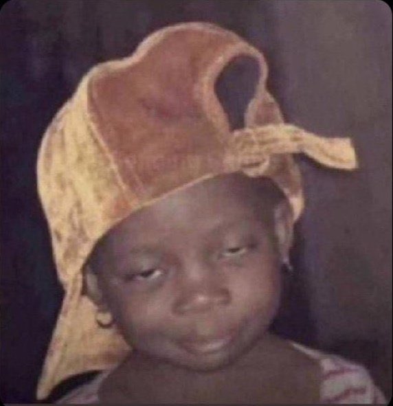 A young child wearing a headwrap looks forward with a calm, hopeful expression, as if waiting expectantly. The image humorously mirrors the post's sentiment of anticipation, depicting someone "awaiting" updates on the $KNOTS creator rewards.