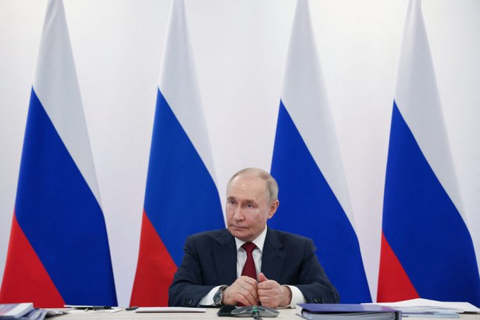 Vladimir Putin sits in front of Russian flags, mirroring the surge in hardware wallet sales in Russia ahead of new crypto rules taking effect September 1.