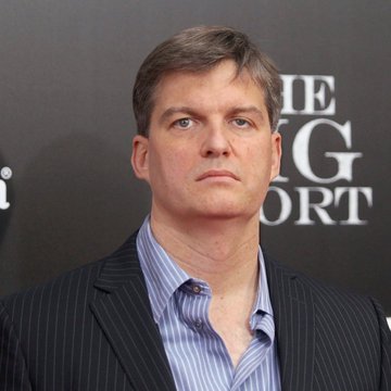 A middle-aged man in a pinstripe blazer over a light blue shirt stands against a dark backdrop displaying partial text reading "ORT," likely from a "Sport" event title. The image appears to be used in connection with a post about Michael Burry's public skepticism of NVIDIA and xAI's financial valuations.