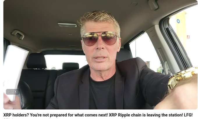 A selfie-style video screenshot showing a man in sunglasses and a black blazer sitting in a car, holding up paper money, with a caption mentioning 'XRP holders' and 'Ripple chain'.
