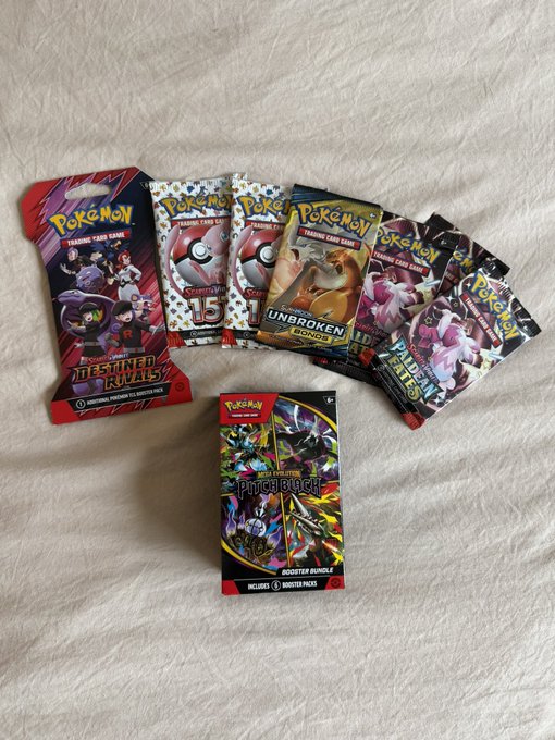 A collection of Pokémon Trading Card Game booster packs fanned out on a white surface, including Destined Rivals, various Sword & Shield-era packs featuring Unbroken Bonds and others, a Prismatic Evolutions pack, and a Phychedelic (Prismatic Evolutions) booster bundle in front.