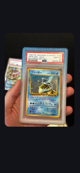 A hand holding a PSA-graded Japanese Pokemon card, identified as a '1998 PM JAPANESE STARTER #114 ARTICUNO - HOLD' graded GEM MT 10.