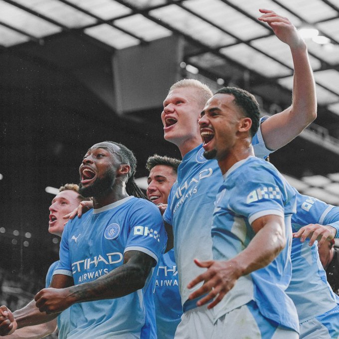 Manchester City players, including Haaland, celebrate exuberantly in their sky blue "Etihad Airways" and "OKX" sponsored jerseys following a derby victory, perfectly capturing the triumphant spirit of the message "DERBY DAY DELIVERED. We go again tomorrow."