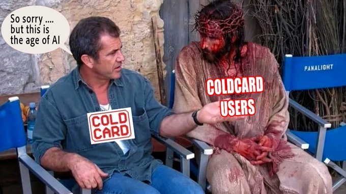Two men are sitting in director's chairs labelled as 'COLD CARD' and 'COLD CARD USERS' respectively, in what appears to be a movie set in the making of the film 'The Passion of the Christ'. The man sitting in the 'COLD CARD' chair is saying "So sorry... but this is the age of AI' to the other seated man.