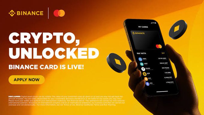 A promotional banner for the Binance Mastercard card featuring the headline 'CRYPTO, UNLOCKED' and 'BINANCE CARD IS LIVE!' with an 'APPLY NOW' button, showing a smartphone displaying a crypto wallet interface.