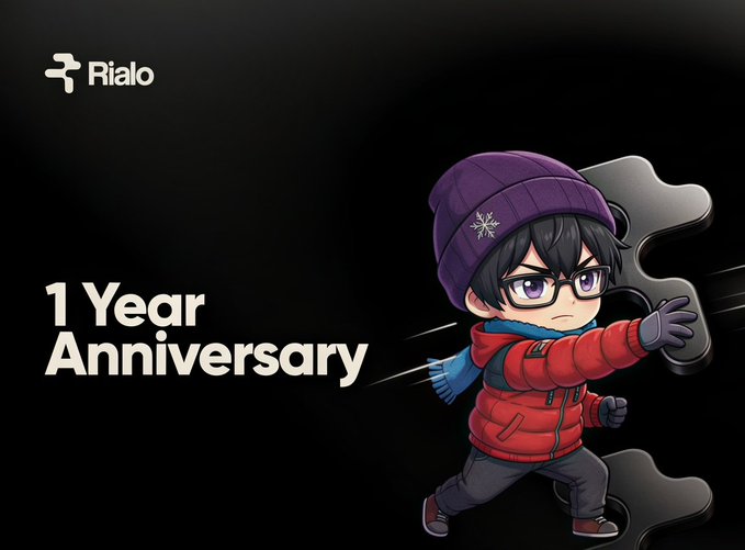 A promotional graphic for 'Rialo' celebrating a '1 Year Anniversary', featuring an anime-style character in a red jacket and purple beanie alongside the company's logo.
