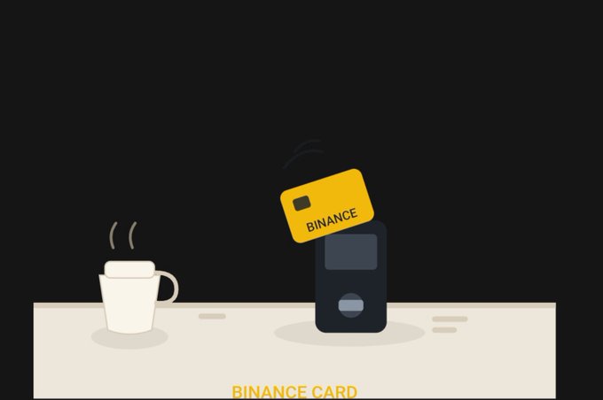 An animated graphic shows a white coffee mug on a table next to a card reader holding a yellow 'BINANCE' card, with 'BINANCE CARD' written in yellow at the bottom.