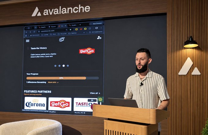 A presenter stands at a podium at an Avalanche Summit event, showing a slide for a 'Taste the Victory' GetGo promotion featuring Corona and GetGo as featured partners.