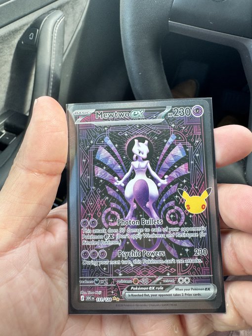 A hand holding a Pokémon trading card, specifically a Mewtwo ex card #230, with a Pikachu visible in the artwork.