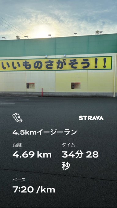 A Strava running screenshot showing a 4.69 km easy run completed in 34 minutes 28 seconds at a 7:20/km pace, with a Japanese sign in the background reading 'いいものさがそぅ!!' (Let's look for good things!!).
