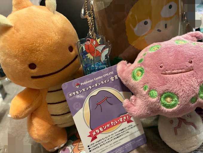 The image shows plush toys of the Pokémon Metamon (Ditto) in both orange and pink forms alongside a Pokémon Center Online membership card featuring the same character, perfectly matching the post's excitement about Metamon merchandise arriving.