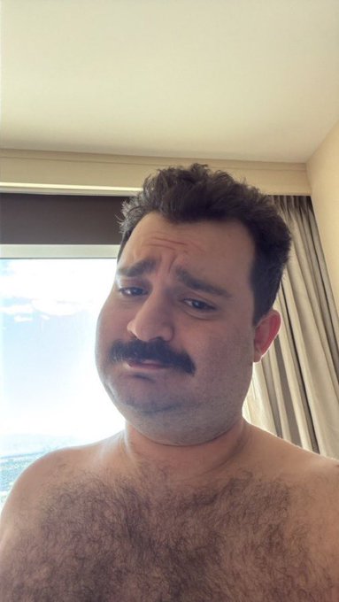 A shirtless, sweaty man with a mustache makes a grimacing, teary-eyed expression, conveying a sense of distress or disappointment—possibly reflecting a negative reaction to the news about Crypto.com's $400 million strategic investment from Citadel Securities involving the CRO token.