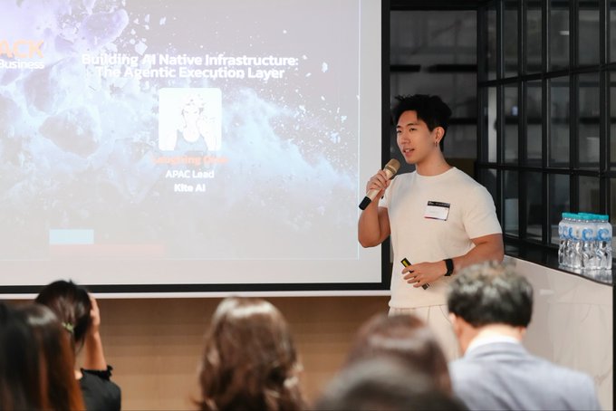 A man in a white t-shirt speaks into a microphone during a presentation; the slide behind him reads 'Building AI Native Infrastructure: The Agentic Execution Layer' and identifies the speaker as 'Jun-Sung Gwak, APAC Lead, Klle AI'.