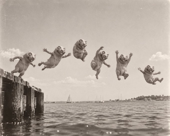 A sepia-toned vintage photograph showing six small figures with grinning, toothy faces leaping sequentially off a wooden pier into a body of water with sailboats in the background.