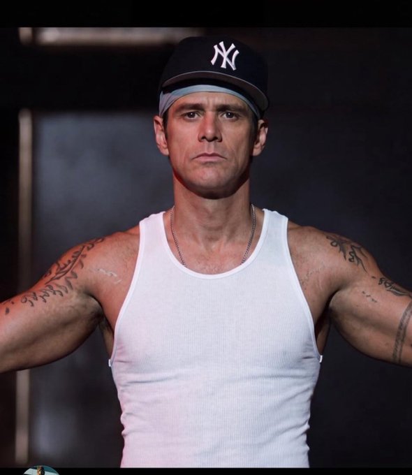 A stern man wearing a black New York Yankees cap and white tank top flexes with a serious expression. The post jokingly implies the man—who resembles Jim Caviezel, rumored to have turned his crypto profits into 1000x gains—is the "key" to such life-changing returns, while the image itself carries no visible text, numbers, or tickers.