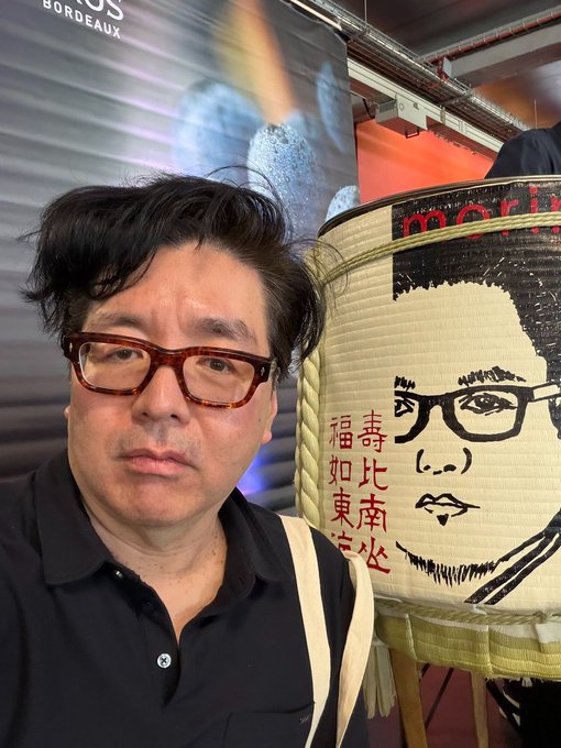 The image features a man wearing glasses standing next to an advertisement for a company named Tom Lee's Bit Mine. The advertisement displays a large sum of money, which could be worth $213 million. This suggests that the company has been successful in their endeavors or is confident about the future value of their assets.