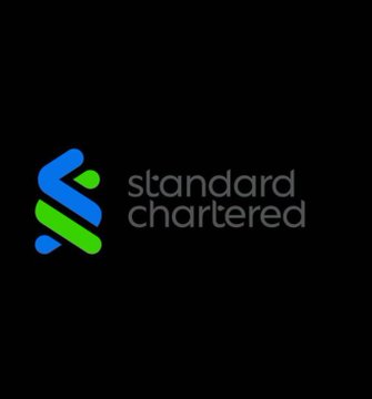 The Standard Chartered bank logo is displayed on a black background, featuring a stylized blue and green knot-like symbol next to the company name in lowercase white text.