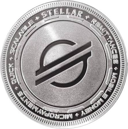 A silver physical Stellar (XLM) cryptocurrency coin featuring the Stellar logo in the center, with text around the edge reading 'STELLAR', 'SCALABLE', 'REMITTANCES', 'MOBILE MONEY', 'MICROPAYMENTS', and 'QUICK'.