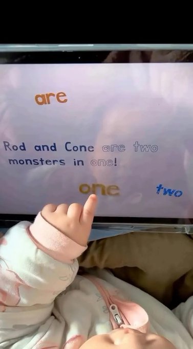 A child's hand pointing at a screen displaying the text 'Rod and Cone are two monsters in one!' with scattered words 'are', 'one', and 'two'.