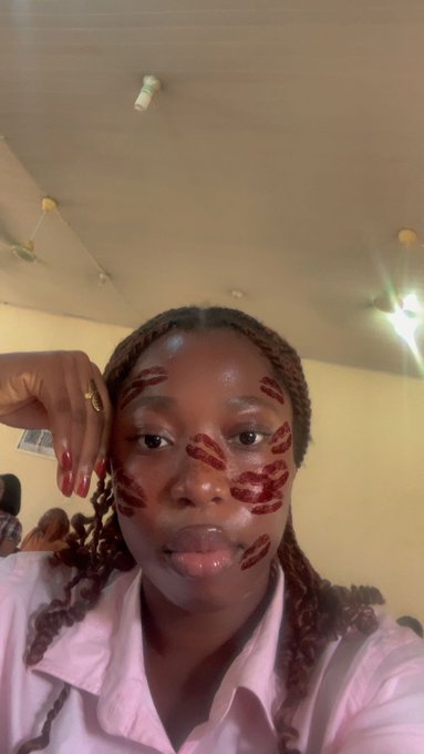 A woman with braided hair and lips-mark beauty spots on her face takes a selfie while wearing a pink shirt, likely waking up and sharing morning vibes with her followers while continuing to promote $RIVER.