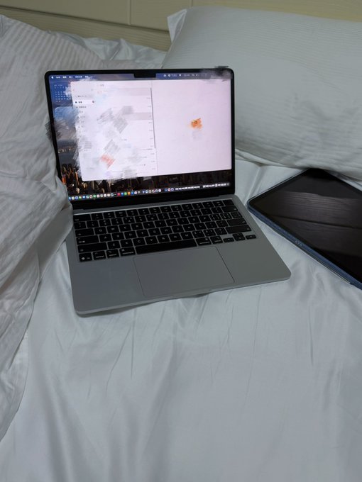 A MacBook Pro displaying what appears to be a coding or design workspace sits open on a white bed, alongside an iPad, capturing a casual work-from-home moment that complements the post's reflection on pursuing a Web3 internship from a personal space.