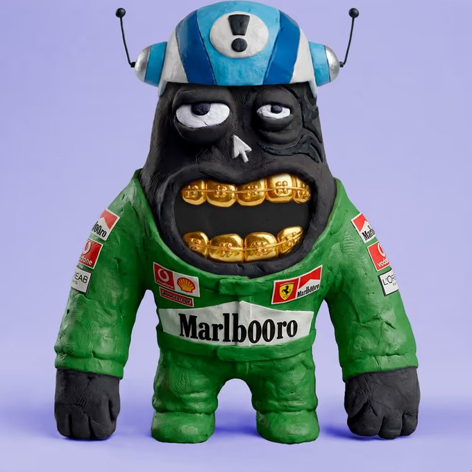 A stylized, monstrous designer toy figure wearing a green Marlboro racing suit with Shell and Ferrari logos, gold grillz, and a blue and white helmet, set against a plain lavender background.