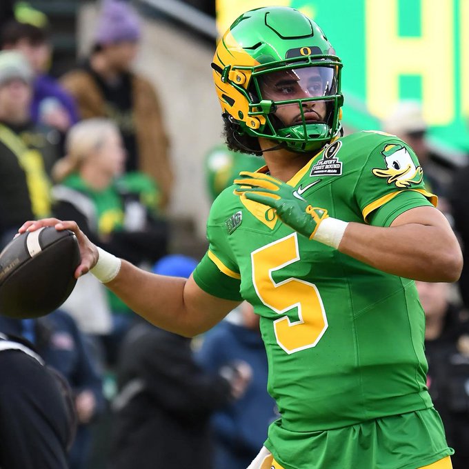 An Oregon Ducks college football player wearing a green and yellow uniform with the number 5 and a helmet, preparing to throw a football during a game.