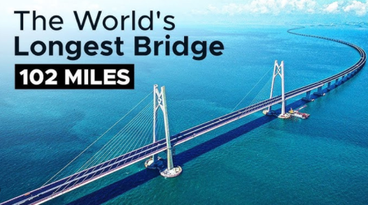 The image shows an aerial view of a long cable-stayed bridge stretching across blue ocean waters, with text overlay reading "The World's Longest Bridge 102 MILES." It relates to the post by using the bridge as a metaphor for the time-consuming process of bridging from SOL (Solana) to a stablecoin, emphasizing the lengthy duration of the cross-chain transaction.
