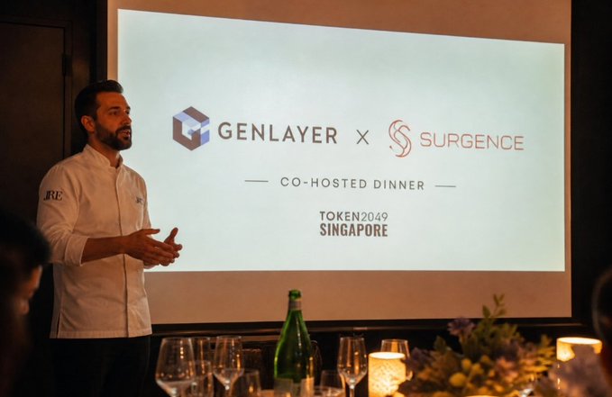 A chef in a white coat speaks at a co-hosted dinner event; the screen behind him displays 'GENLAYER x SURGENCE', 'CO-HOSTED DINNER', and 'TOKEN2049 SINGAPORE'.