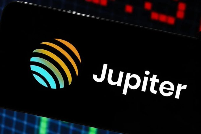 A close-up image of the Jupiter logo displayed on a device screen, featuring a teal and orange gradient globe design next to the white 'Jupiter' text.