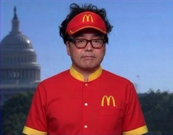 A man wearing a McDonald's uniform and visor stands in front of the US Capitol building, looking directly at the camera.
