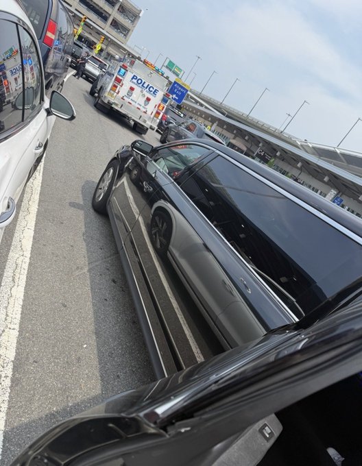 A police vehicle marked "POLICE" is parked behind a black car on what appears to be a highway or toll plaza, suggesting a traffic stop or roadside incident. The image seems unrelated to the post's commentary on art and cryptocurrency, possibly serving as a metaphor for being "caught" or "held back" by volatility in crypto markets.