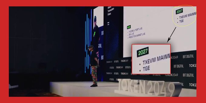 A photo from a conference showing a man on stage, with an inset highlighting a slide that reads "2027 - TXEVM MAINNET - TGE," while the stage displays "TOKEN2049."