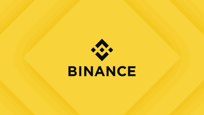 The Binance logo displayed on a yellow geometric background.
