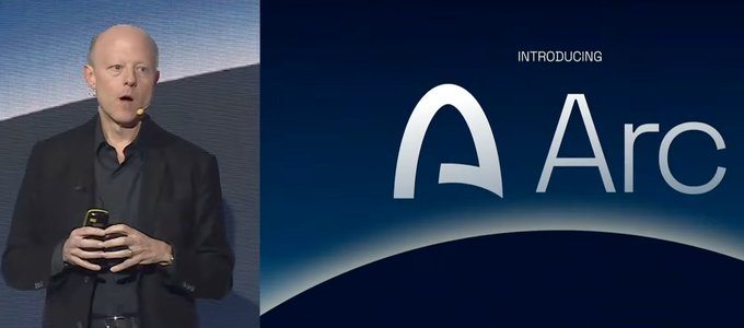 A bald man in a black jacket speaking at a presentation, with a screen beside him displaying 'INTRODUCING Arc' with a stylized 'A' logo.
