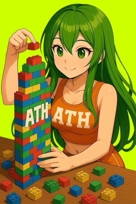 An anime-style illustration shows a green-haired girl in an orange 'ATH ATH' shirt building a colorful block tower on a wooden table.